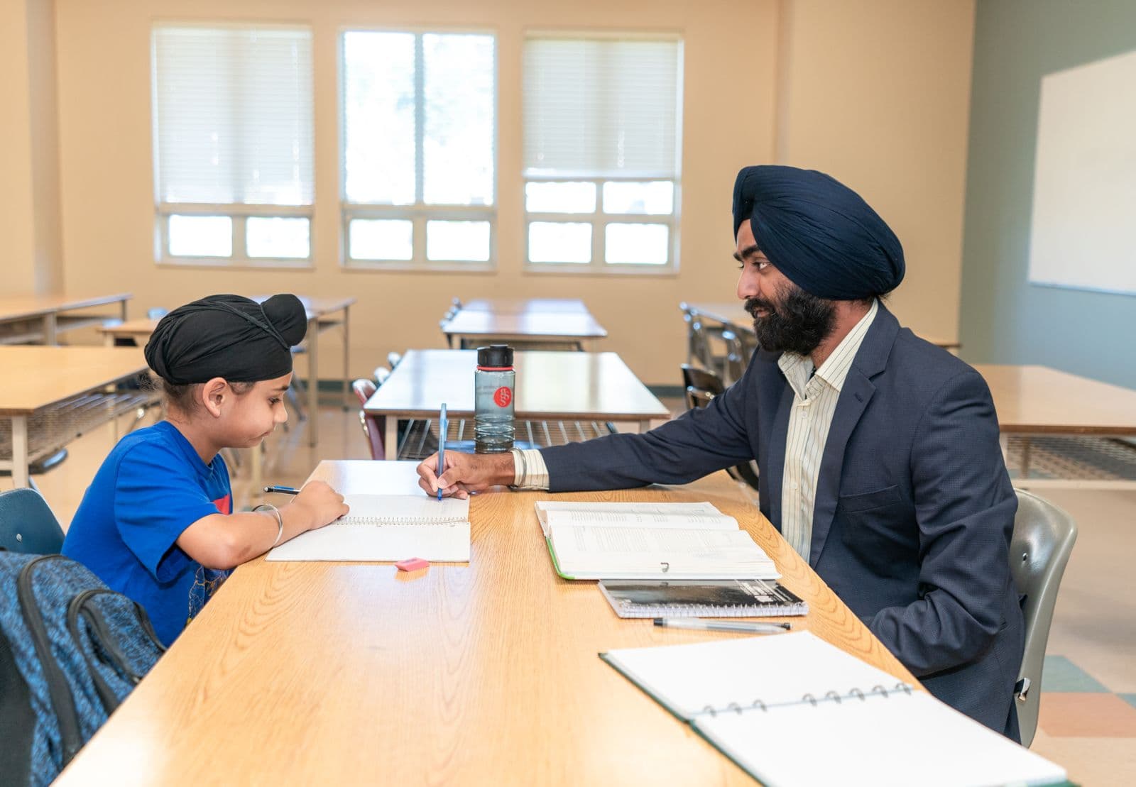 A teacher supporting a student with written work
